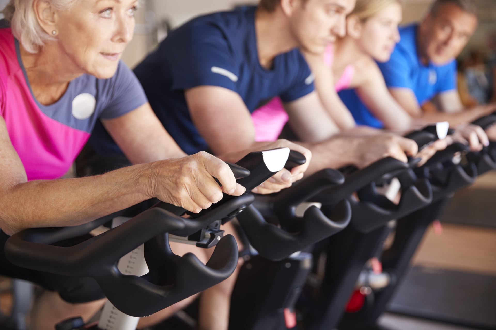A row of bikes and handlebars lined up in the studio before class