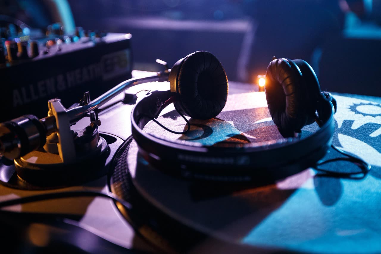 Headphones resting on a turntable, standing in for the studio's playlist culture
